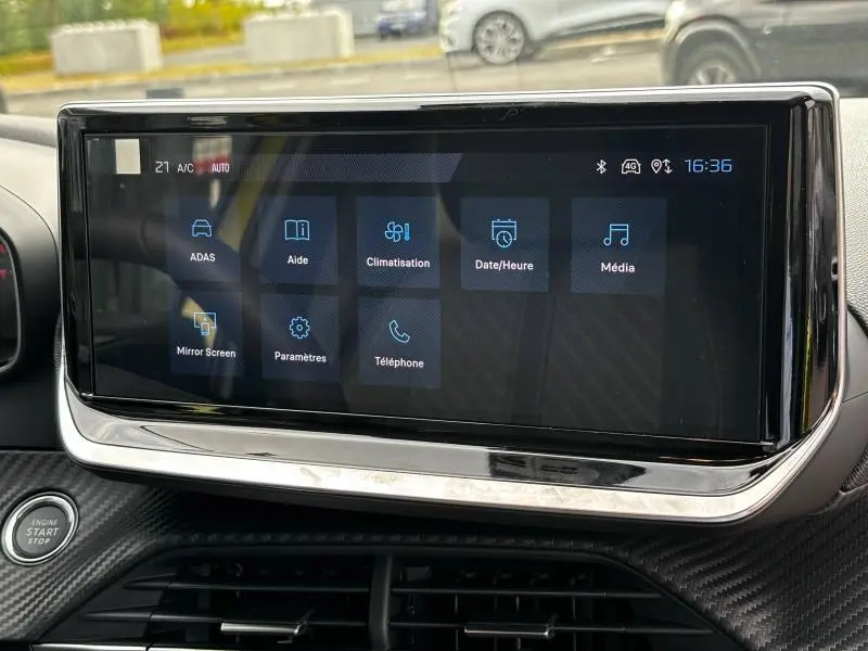 Écran tactile central du tableau de bord du Peugeot 208 2024 affichant les menus climatisation et média.
