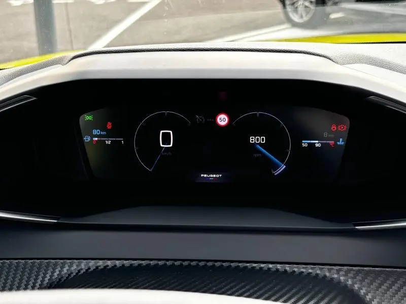 Vue rapprochée du tableau de bord numérique noir du Peugeot 208 2024, affichant la vitesse et le régime moteur.