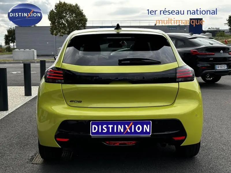 Vue arrière d'une Peugeot 208 1.2 PureTech jaune Agueda avec feux arrière LED et bande noire distinctive.