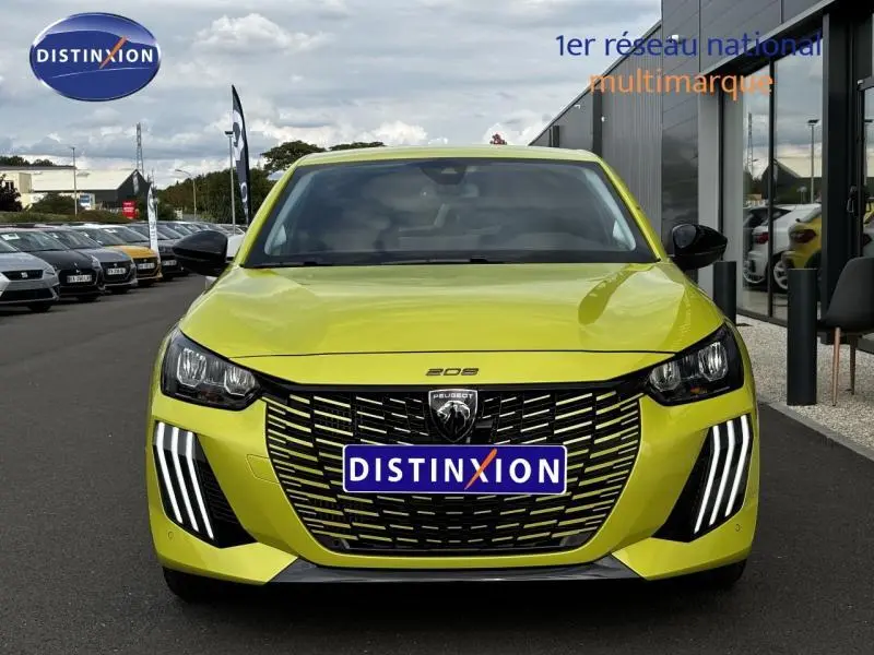 Vue frontale d'une Peugeot 208 2024 jaune Agueda avec calandre noire et feux LED verticaux distinctifs.