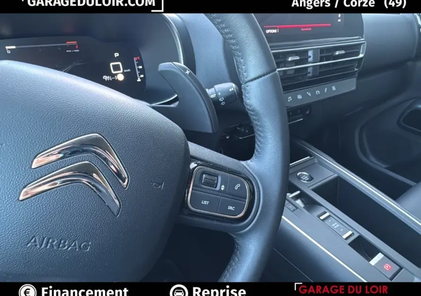 Gros plan sur le volant cuir noir et le tableau de bord digital du Citroën C5 Aircross 2025, intérieur moderne et épuré.