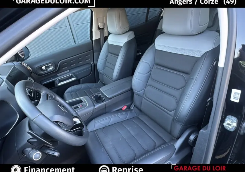 Vue intérieure côté conducteur du Citroën C5 Aircross noir 2025, sièges cuir bicolore et volant multifonctions.