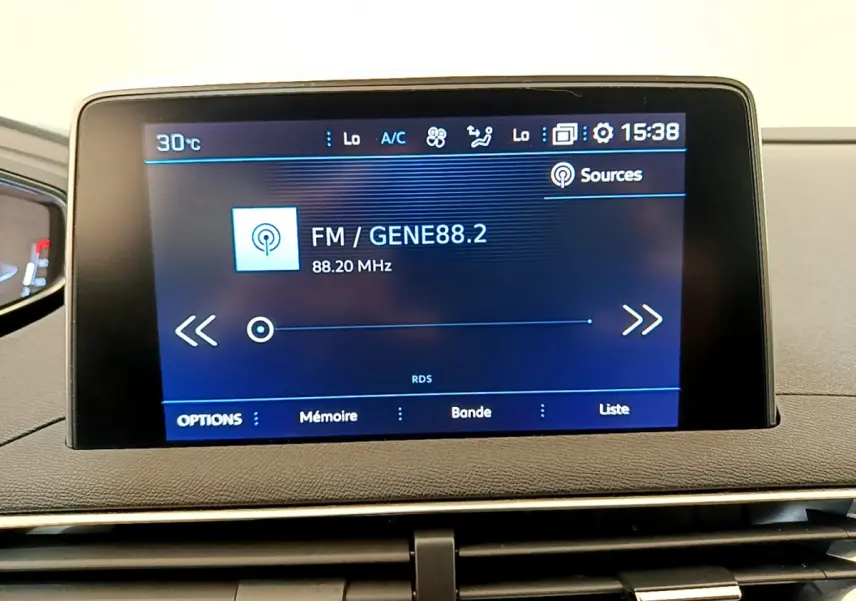 Écran tactile central affichant la radio FM dans l’habitacle du Peugeot 3008 gris foncé, version Puretech 130 S&S ACTIVE.