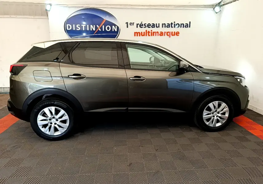 Vue de profil côté gauche d'un Peugeot 3008 gris foncé version Puretech 130 S&S ACTIVE en intérieur showroom.