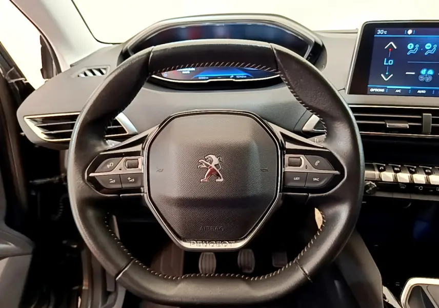 Vue intérieure centrée sur le volant cuir noir du Peugeot 3008 Puretech 130 S&S Active avec tableau de bord digital.