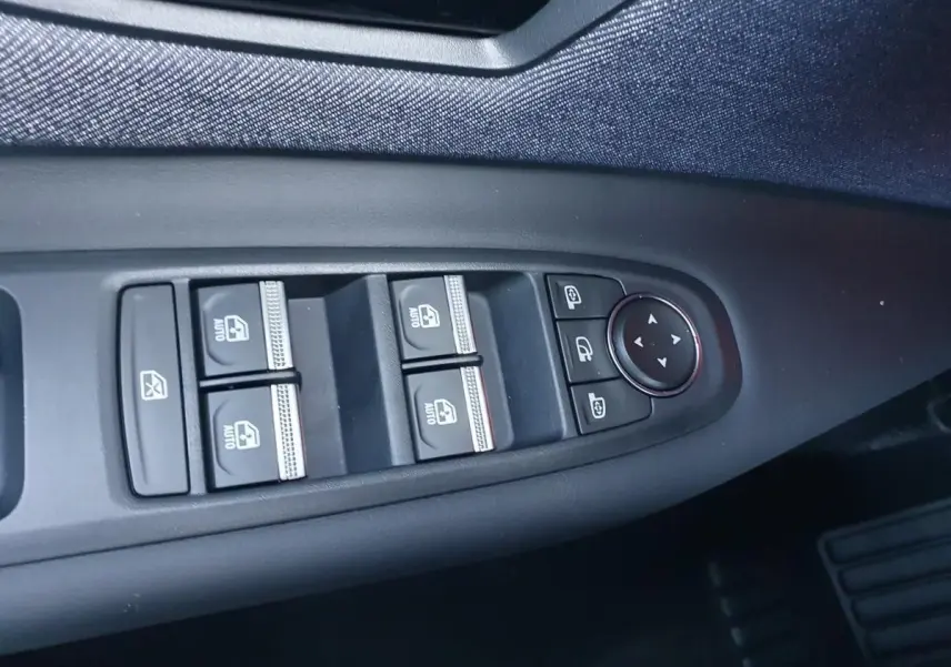 Commande des vitres électriques et réglages des rétroviseurs sur la porte côté conducteur d'une Renault R5 jaune Pop 2026.