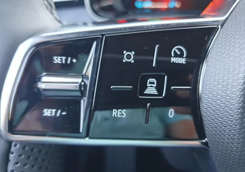 Gros plan sur les commandes au volant noir brillant de la Renault R5 E-TECH jaune Pop, avec boutons de régulateur de vitesse.