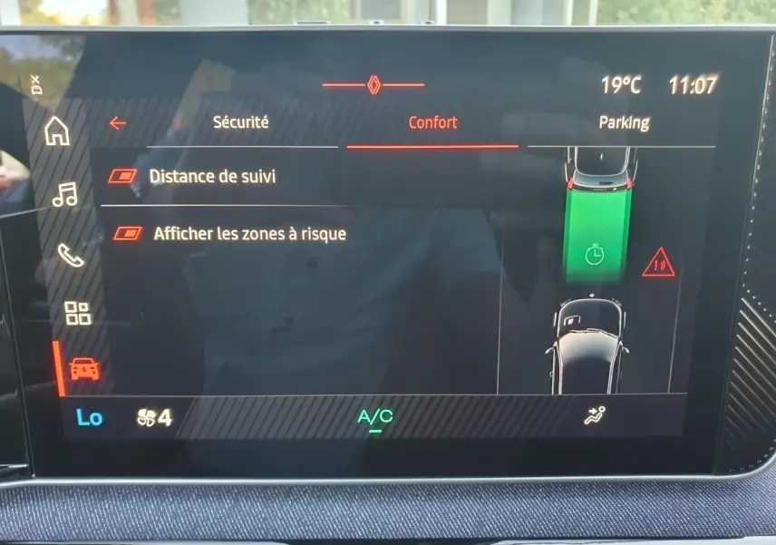 Écran tactile central de la Renault R5 E-TECH jaune, affichant les réglages de sécurité et assistance au stationnement.