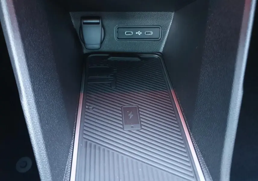 Gros plan sur la zone de recharge sans fil et les ports USB-C dans le compartiment central de la Renault R5 E-TECH jaune pop.