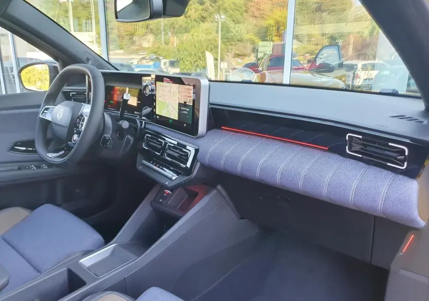 Intérieur Renault R5 E-Tech 2026 côté conducteur, tableau de bord moderne avec écran tactile et tissu bleu clair.