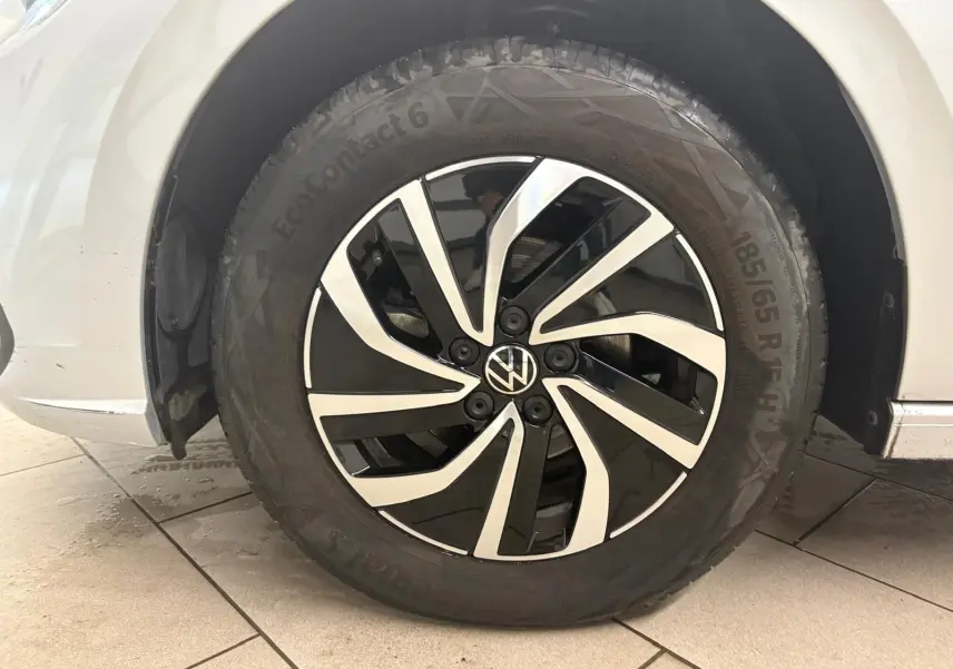 Gros plan sur la roue avant gauche d'une Volkswagen Polo 2024 argentée avec jante noire et argentée au design moderne.