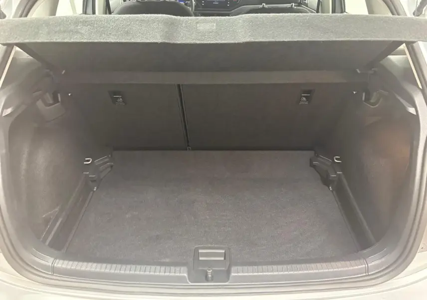 Vue intérieure du coffre spacieux et propre d'une Volkswagen Polo 2024 en Reflet d'argent, avec banquette arrière visible.