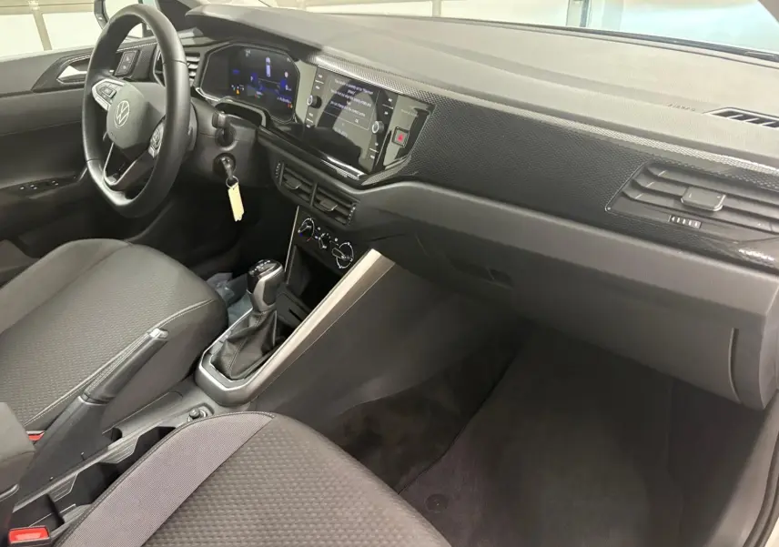 Intérieur avant droit de la Volkswagen Polo 2024 avec tableau de bord moderne et boîte automatique visible.