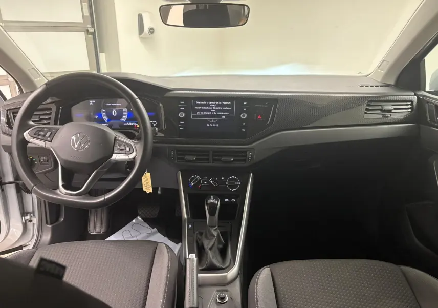 Intérieur de Volkswagen Polo 2024 en Reflet d'argent, vue du poste de conduite avec volant multifonction et écran tactile central.