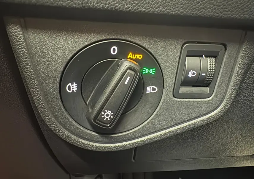 Gros plan sur le sélecteur de phares avec mode automatique activé dans une Volkswagen Polo Reflet d'argent 2024.