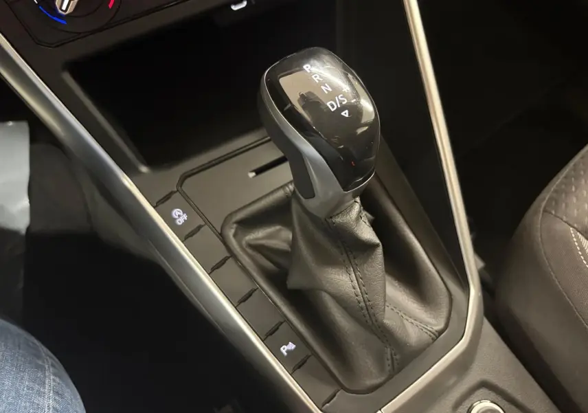 Le levier de vitesse automatique de la Volkswagen Polo 2024 en cuir noir, vue rapprochée de la console centrale.