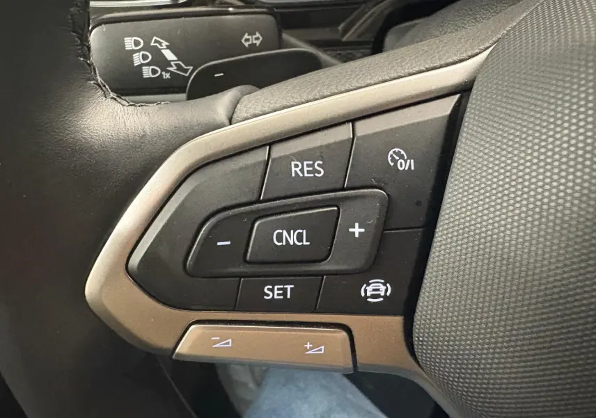 Gros plan sur les commandes au volant du Volkswagen Polo 2024, finition Life, avec boutons de régulateur de vitesse.