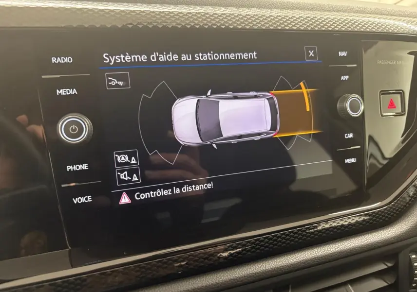 Écran central affichant le système d'aide au stationnement du Volkswagen Polo 2024 en peinture métallisée Reflet d'argent.