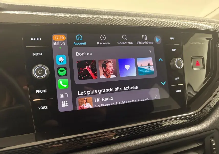 Vue rapprochée de l'écran tactile multimédia intérieur d'une Volkswagen Polo 2024 avec interface connectée et commandes autour.