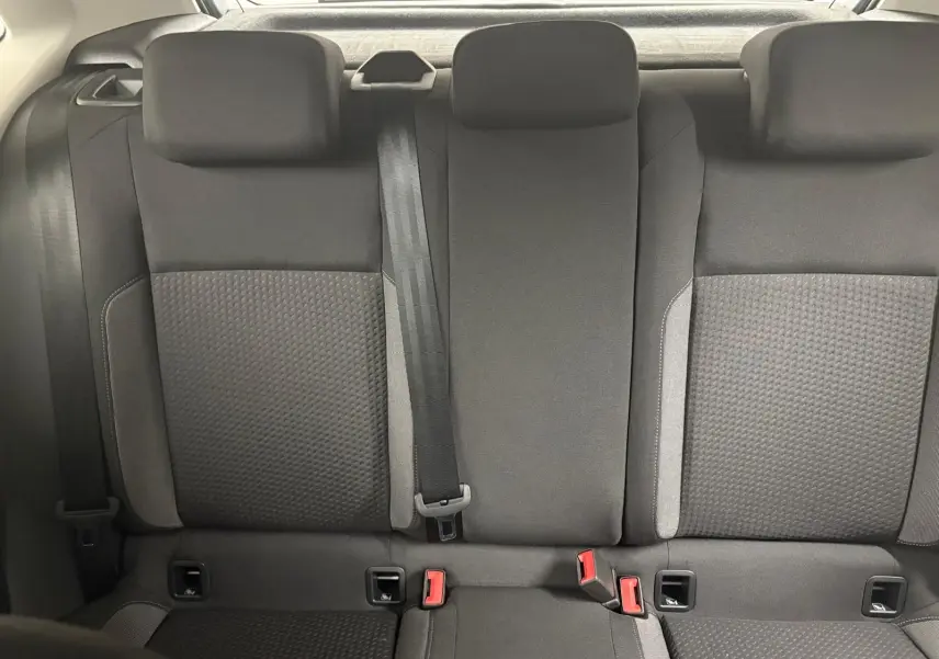 Vue arrière des sièges arrière en tissu gris foncé de la Volkswagen Polo 2024, avec ceintures et appuie-têtes visibles.