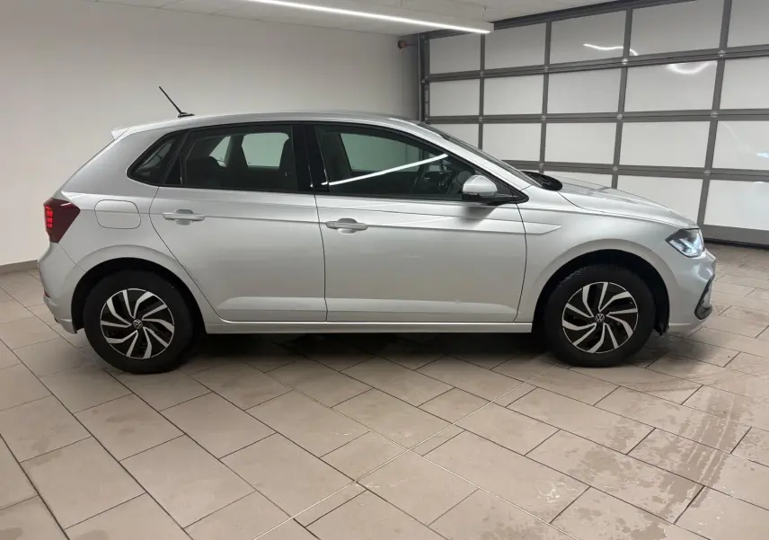 Profil droit d'une Volkswagen Polo 2024 en peinture métallisée Reflet d'argent, avec jantes au design moderne et caméra de recul visible.