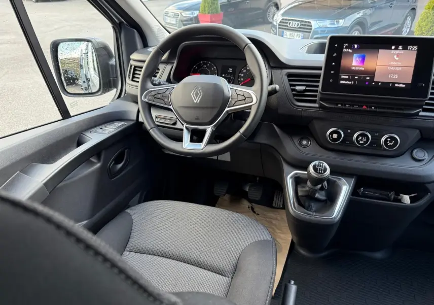 Vue intérieure côté droit du Renault Trafic cabine approfondie 2025 gris Highland, montrant les sièges arrière et avant en tissu bicolore.