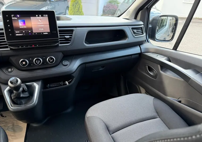 Vue arrière du Renault Trafic cabine approfondie gris Highland, montrant l'espace de chargement métallique vide et les portes ouvertes.