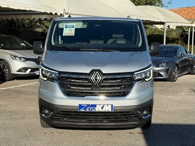Gros plan sur l'avant droit gris Highland du Renault Trafic cabine approfondie 2025 avec calandre noire et phares LED.