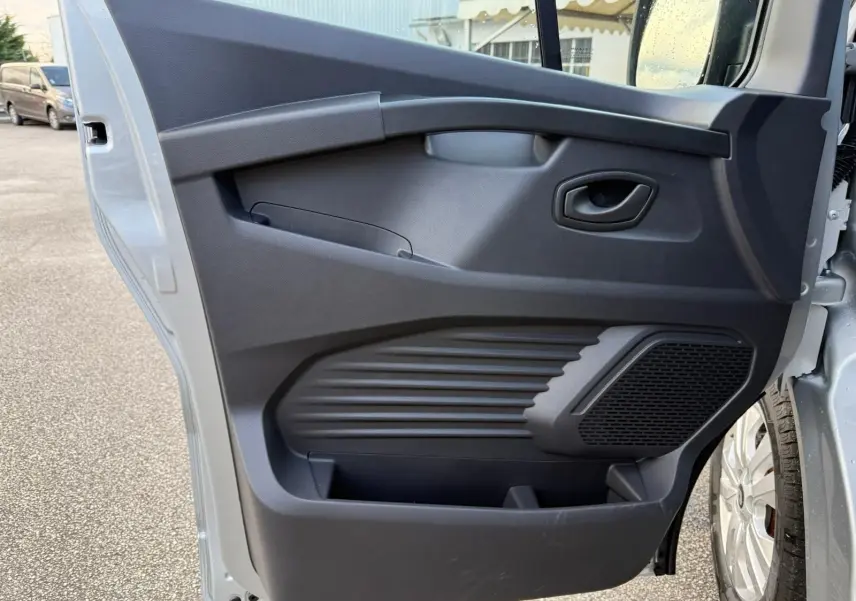 Vue arrière d'un Renault Trafic cabine approfondie gris Highland avec portes battantes et feux arrière verticaux.