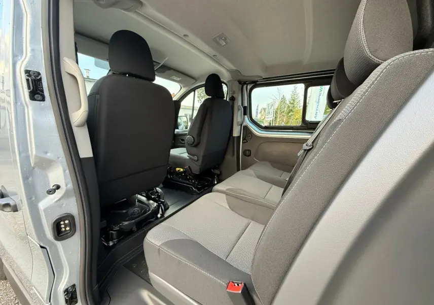 Vue 3/4 avant droit d’un Renault Trafic cabine approfondie gris Highland avec jantes alliage et calandre noire.