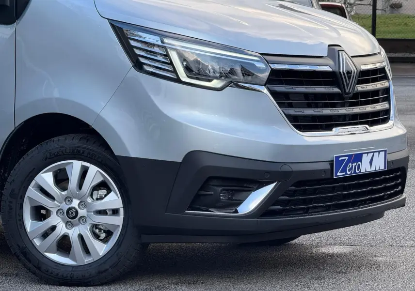 Renault Trafic cabine approfondie gris Highland en 3/4 avant droit, avec calandre noire et jantes argentées.