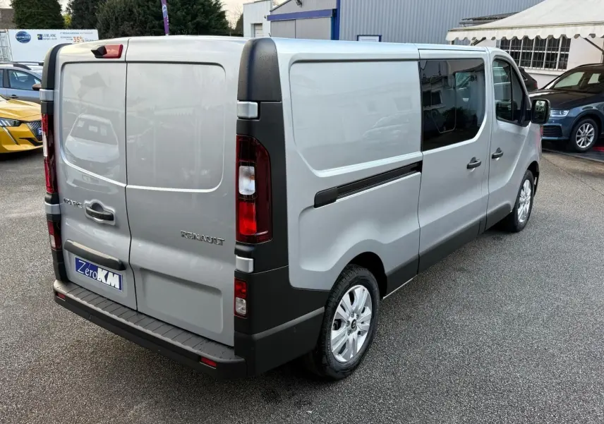 Vue intérieure côté conducteur du Renault Trafic cabine approfondie 2025, sièges gris et volant noir visibles.