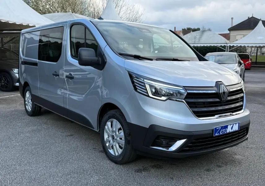 Vue 3/4 avant droit d'un Renault Trafic cabine approfondie gris Highland avec calandre noire et jantes argentées.