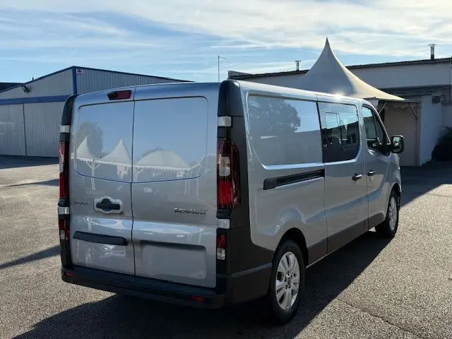 Renault Trafic cabine approfondie gris Highland vu de profil côté gauche, avec fenêtres teintées et jantes alliage.