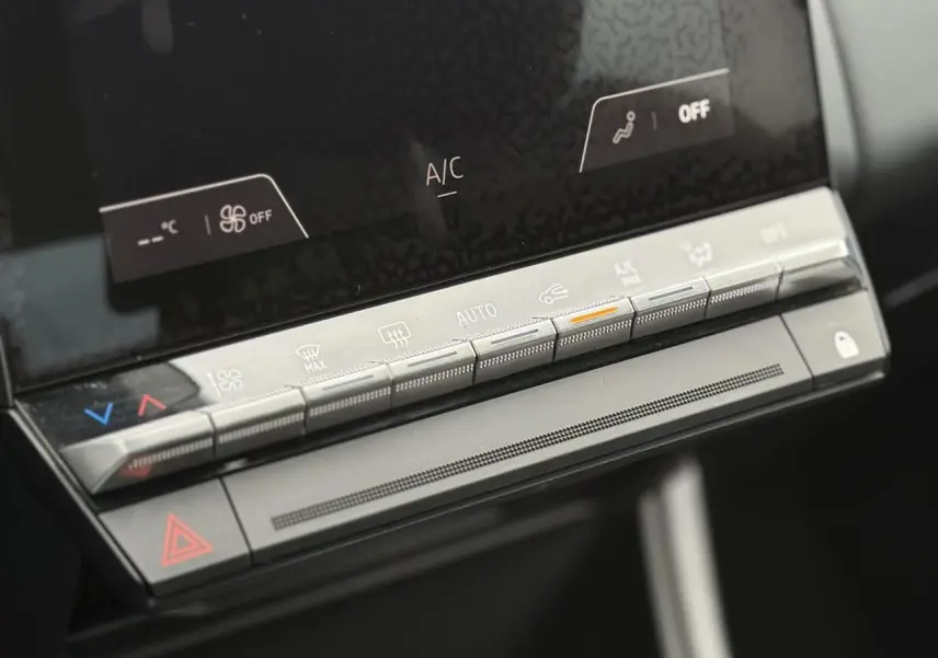Détail de la console centrale avec commandes climatisation et écran tactile du Renault Captur hybride 2025.