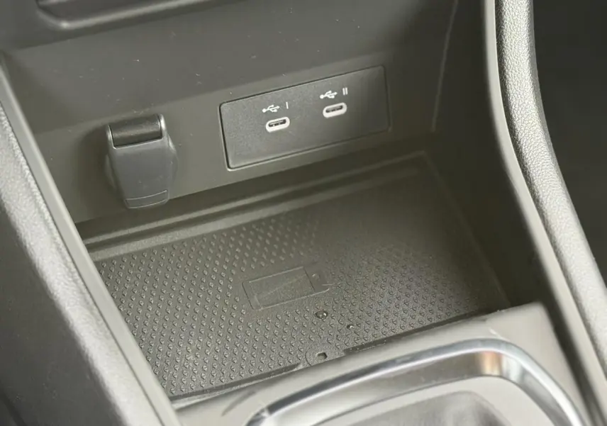 Gros plan sur la console centrale noire du Renault Captur avec deux ports USB-C et un espace de charge sans fil.