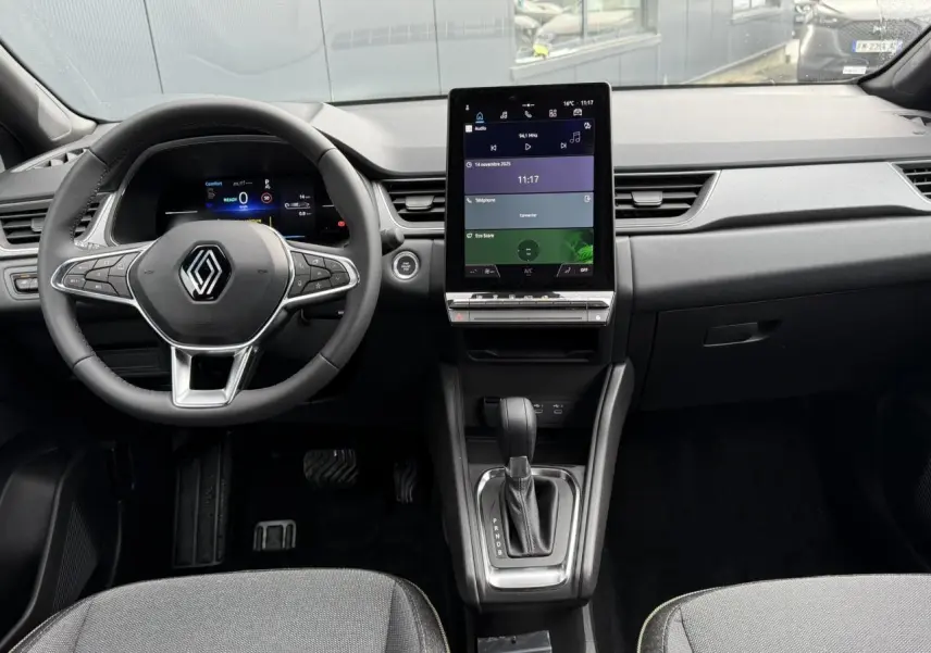 Vue intérieure frontale du tableau de bord du Renault Captur 2025 avec écran tactile vertical et volant multifonction.