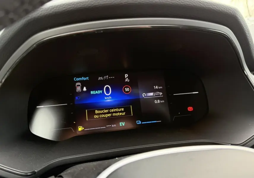 Tableau de bord numérique du Renault Captur hybride 2025 affichant vitesse, mode confort et alertes de sécurité.