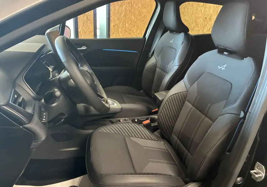 Vue intérieure côté conducteur du Renault Captur E-Tech Full Hybrid 2025, sièges noirs avec logo Alpine brodé.