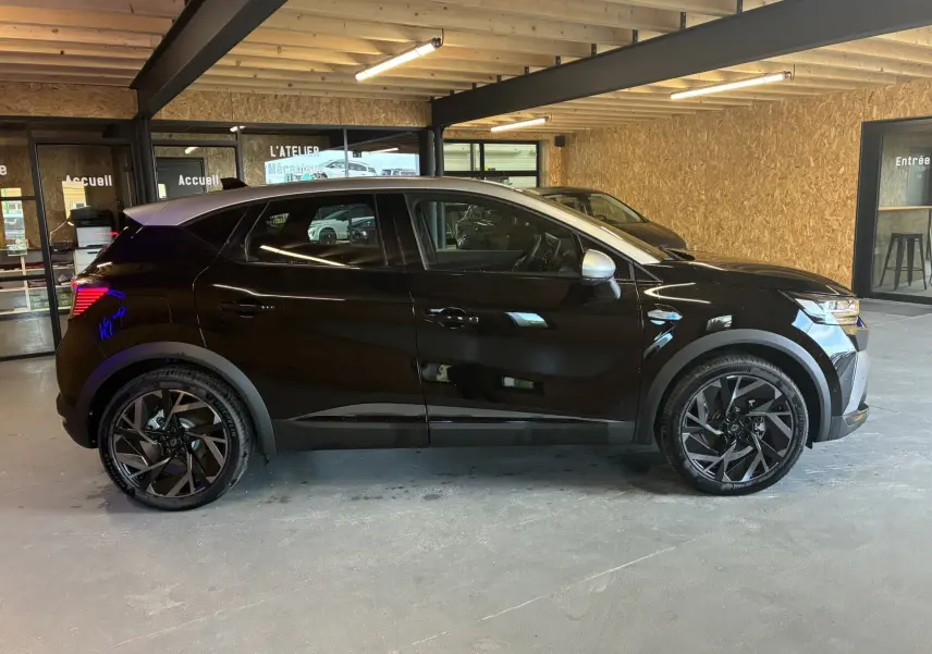 Profil côté gauche du Renault Captur E-Tech Full Hybrid 145ch Esprit Alpine 2025 noir étoile métal avec toit gris en intérieur showroom.
