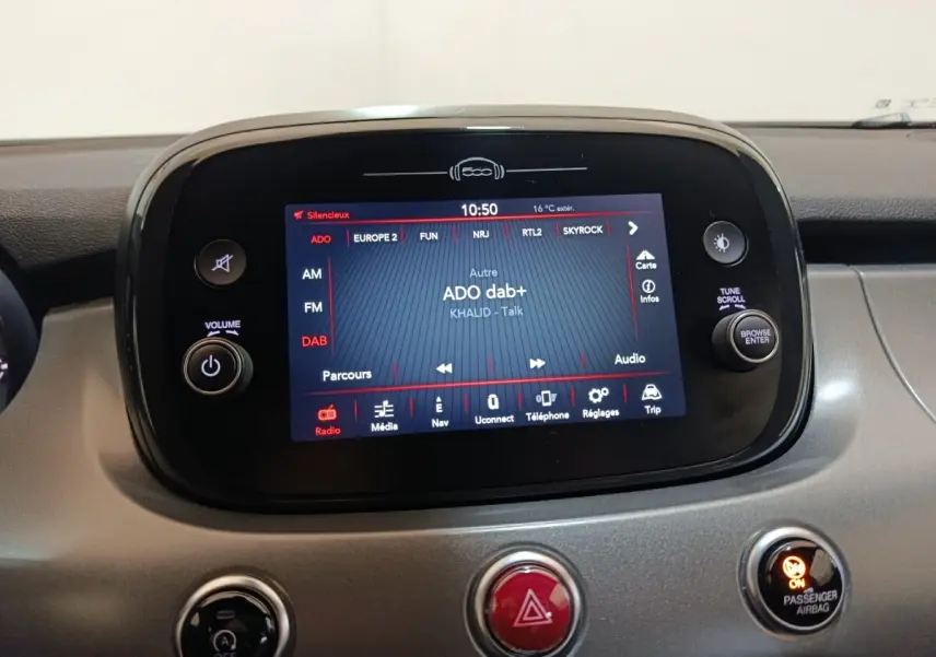 Écran tactile central allumé du tableau de bord de la Fiat 500X noir, affichant la radio DAB+ et les commandes multimédia.