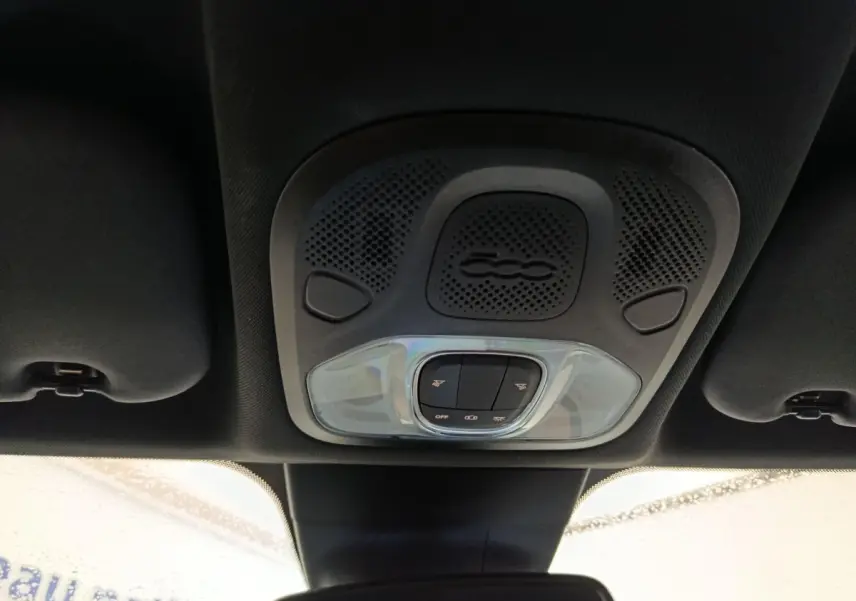 Vue intérieure du plafonnier noir avec commandes d’éclairage et haut-parleur marqué du logo 500 sur Fiat 500X.