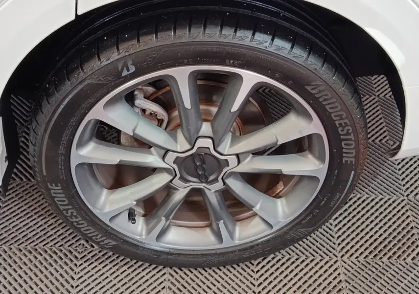Gros plan sur la roue avant droite argentée du FIAT 500X noir, avec pneu Bridgestone et jante à multiples branches.