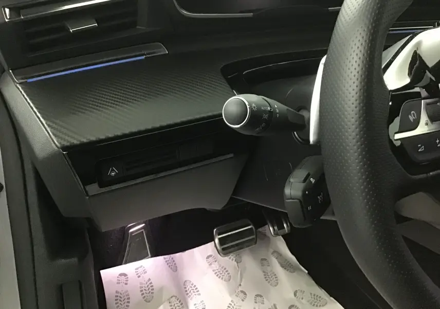 Vue rapprochée côté gauche du poste de conduite du Peugeot 508 SW gris Artense, avec volant perforé et commandes au volant visibles.