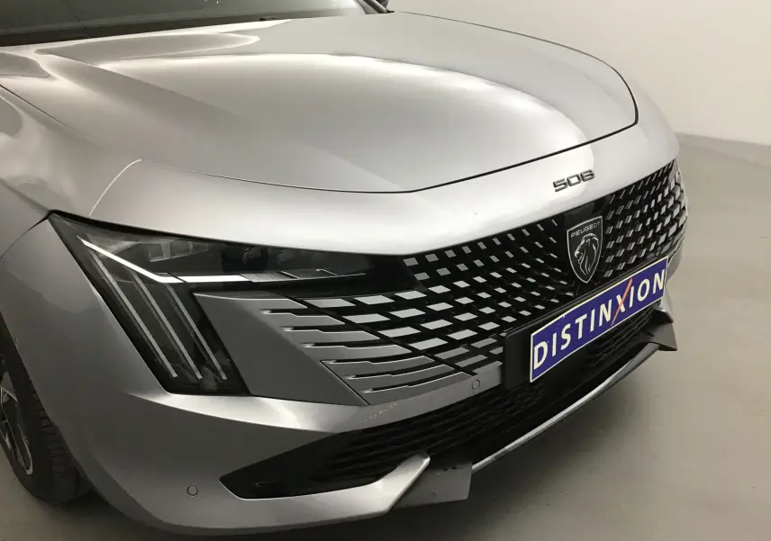 Vue de face en léger angle droit d'une Peugeot 508 SW gris Artense avec calandre noire à motifs et phares Full LED.
