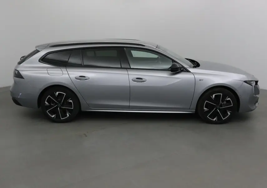 Profil côté droit de la Peugeot 508 SW gris Artense 2024, finition GT avec jantes noires et toit panoramique.