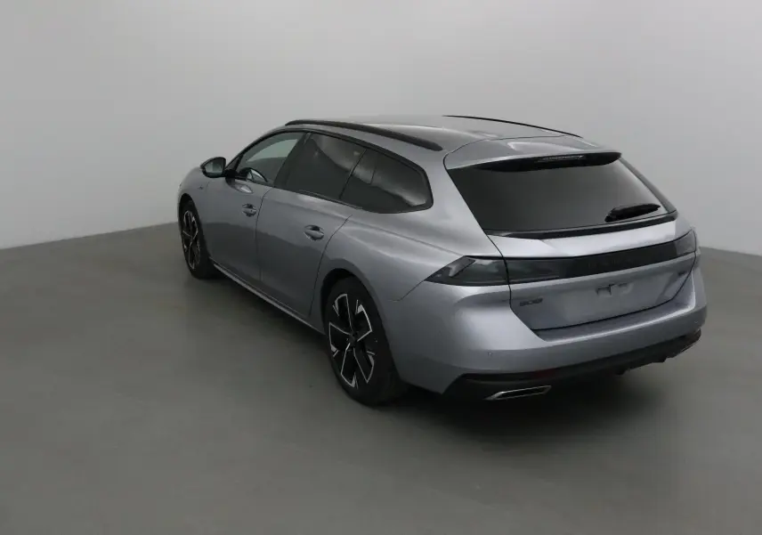 Peugeot 508 SW gris Artense vue 3/4 arrière droit, avec vitres teintées et jantes noires distinctives.