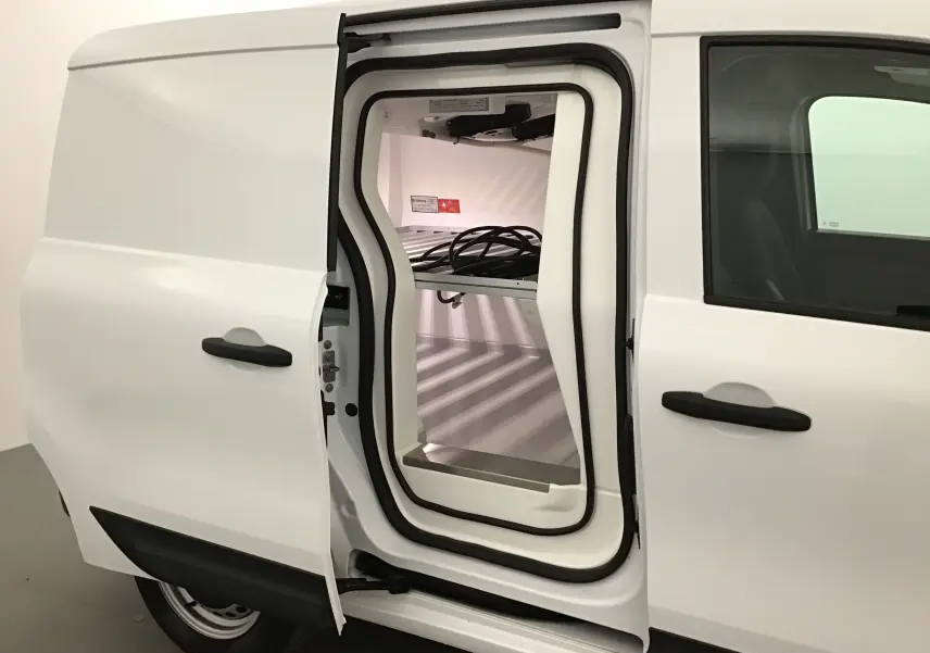 Vue latérale gauche du Renault Kangoo blanc 2022 avec porte coulissante ouverte montrant la cellule frigo isolée intérieure.