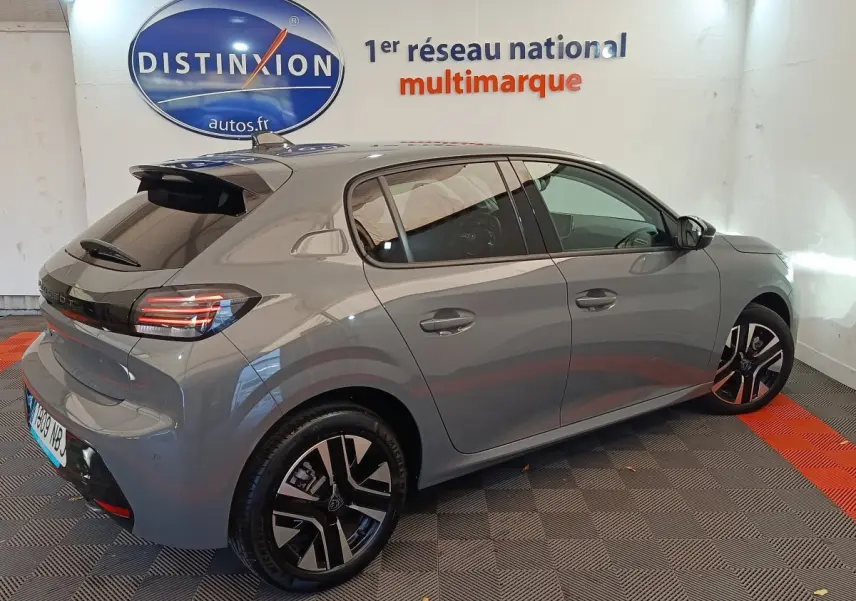 Peugeot 208 PureTech 100 S&S Allure gris foncé vue 3/4 arrière droit en intérieur showroom.