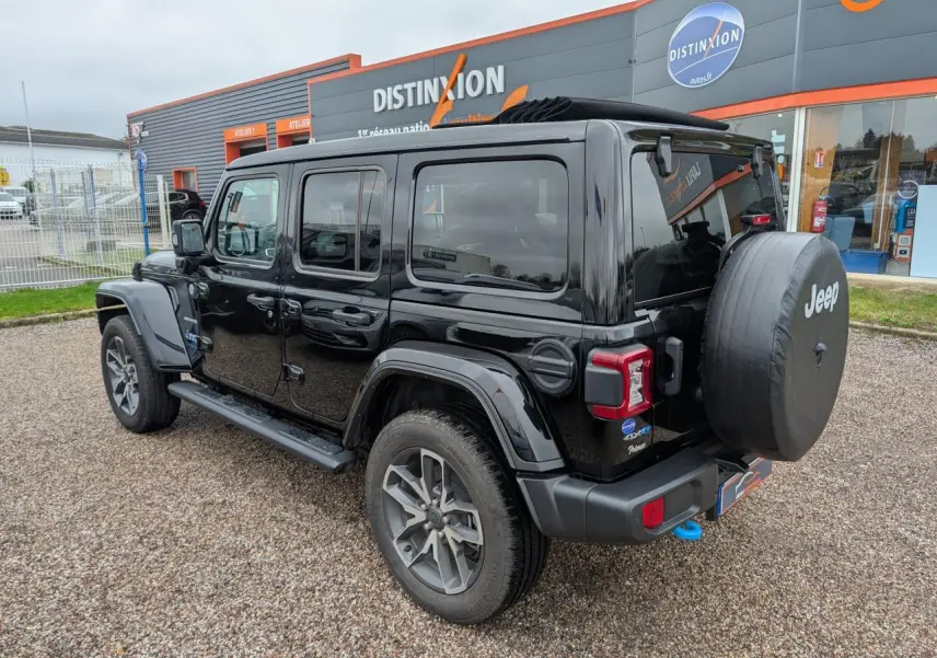 Jeep Wrangler 2024 noir vue 3/4 arrière droit avec roue de secours et marchepied visible.